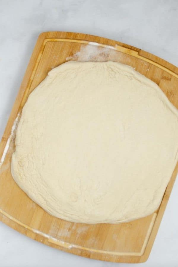pizza dough that has been rolled out on a cutting board