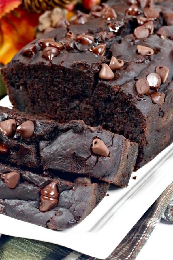 soft and moist loaf of chocolate pumpkin bread, sliced on a white plate