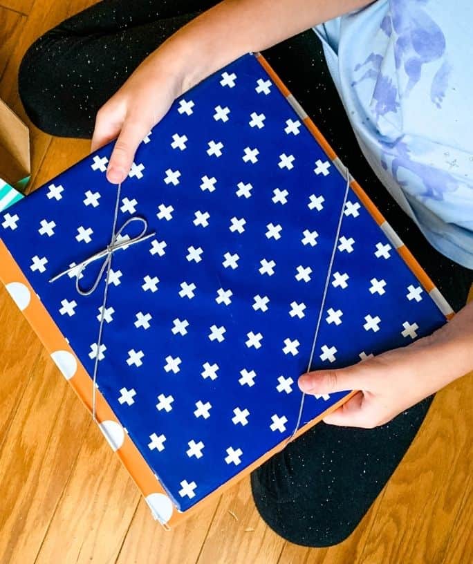 child holding two books from a bookroo subscription box