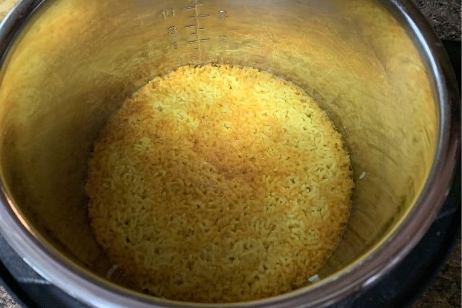 Freshly cooked yellow rice in the insert pot of the pressure cooker