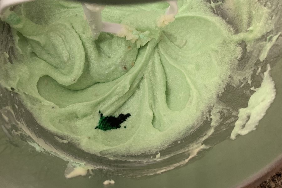 green pistachio pudding cookie batter and food coloring in a mixer bowl