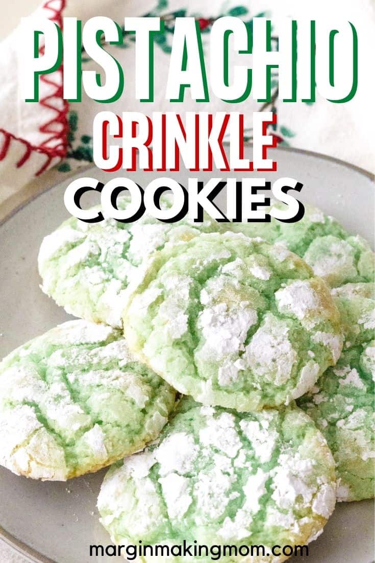 plate of pistachio crinkle cookies next to a holiday tea towel