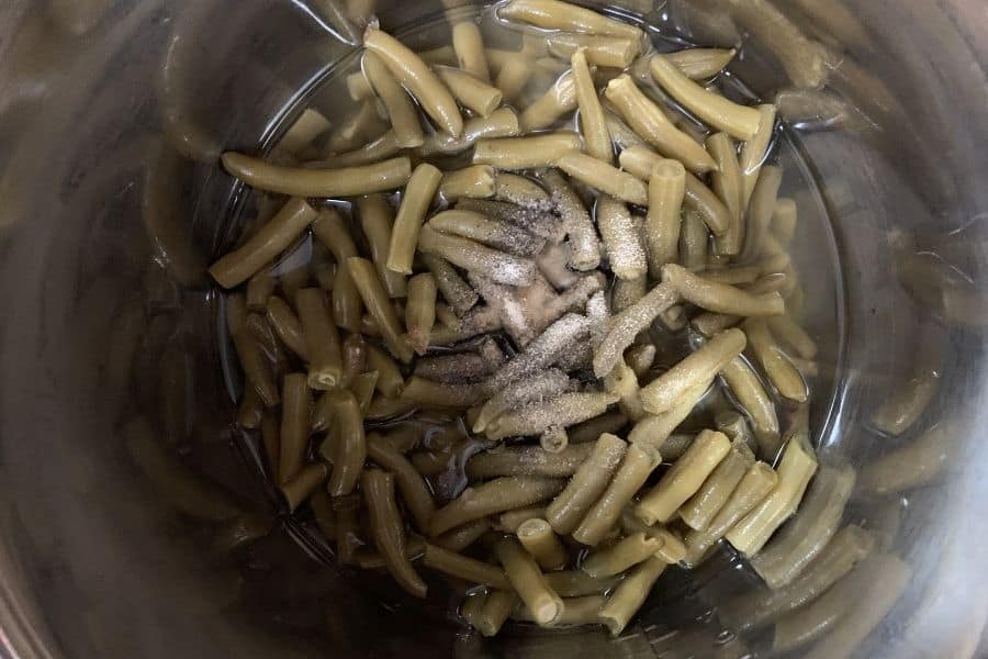 canned green beans and seasonings in the Instant Pot pressure cooker