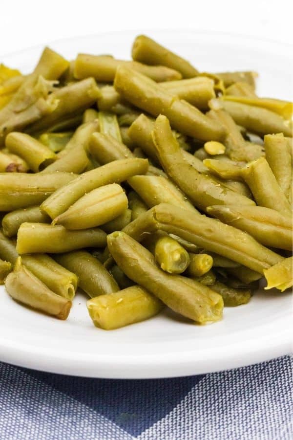 a white plate with a helping of homestyle green beans cooked in the Instant Pot from a can.