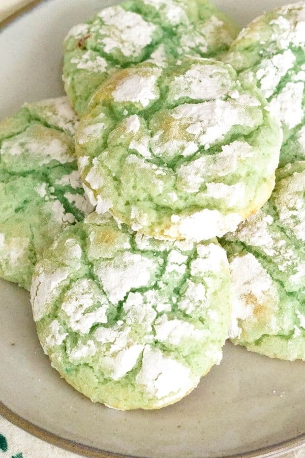 plate of pistachio pudding cookies that have been rolled in powdered sugar