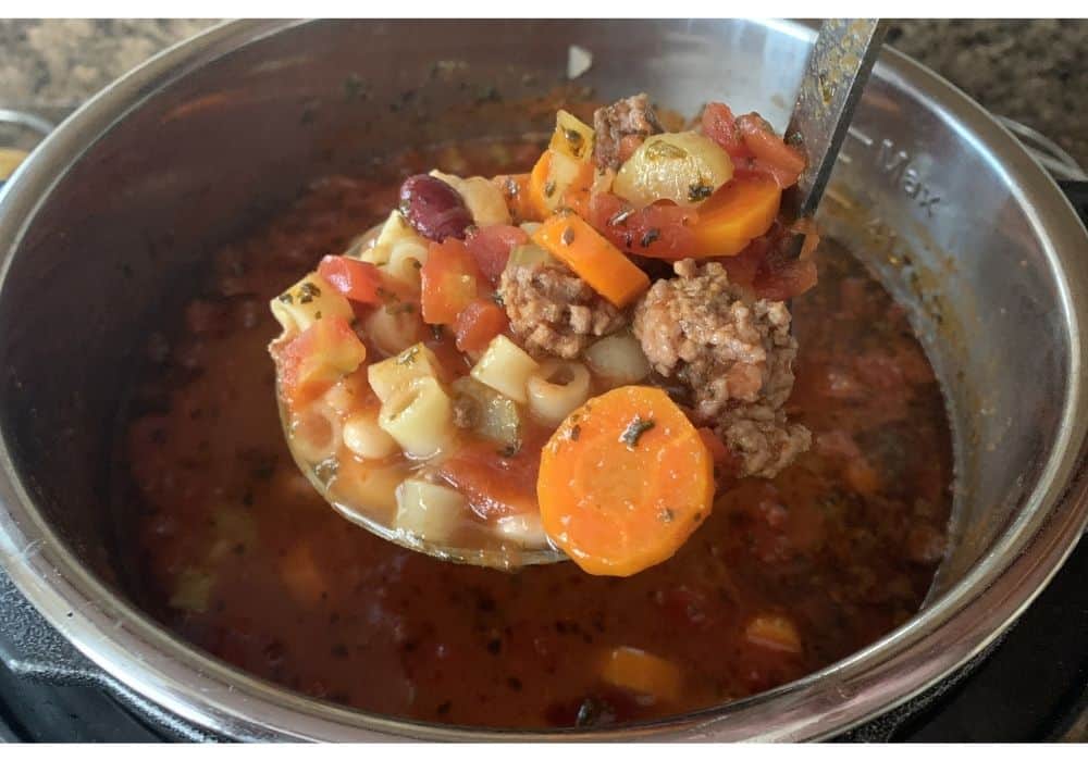 a ladle scooping out pasta e fagioli in the Instant Pot