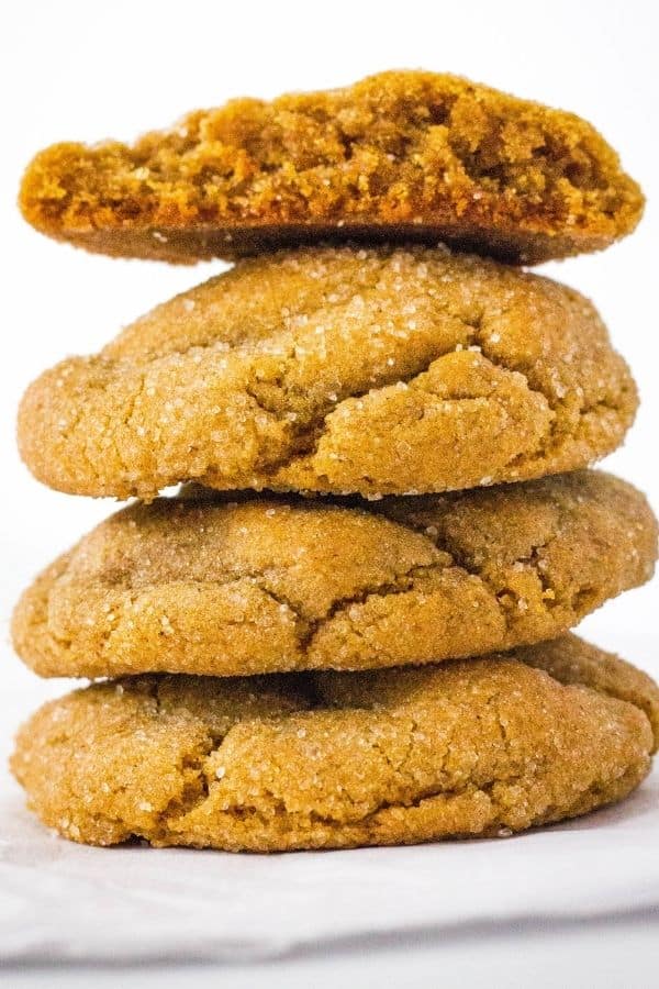 stack of four old-fashioned ginger molasses cookies, with the top cookie broken in half to show the interior.