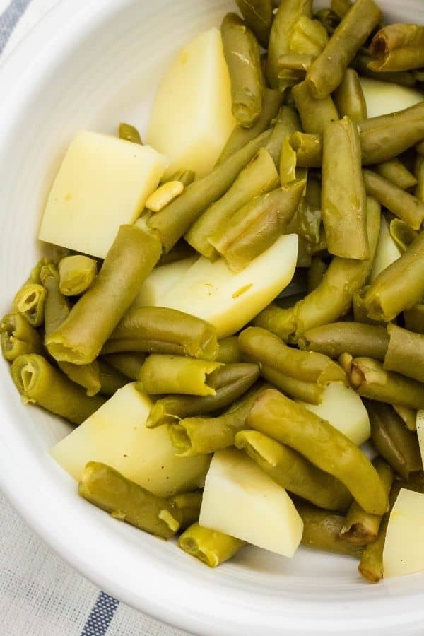 close-up view of green beans and potatoes that were cooked in the Instant Pot, being served in a white dish