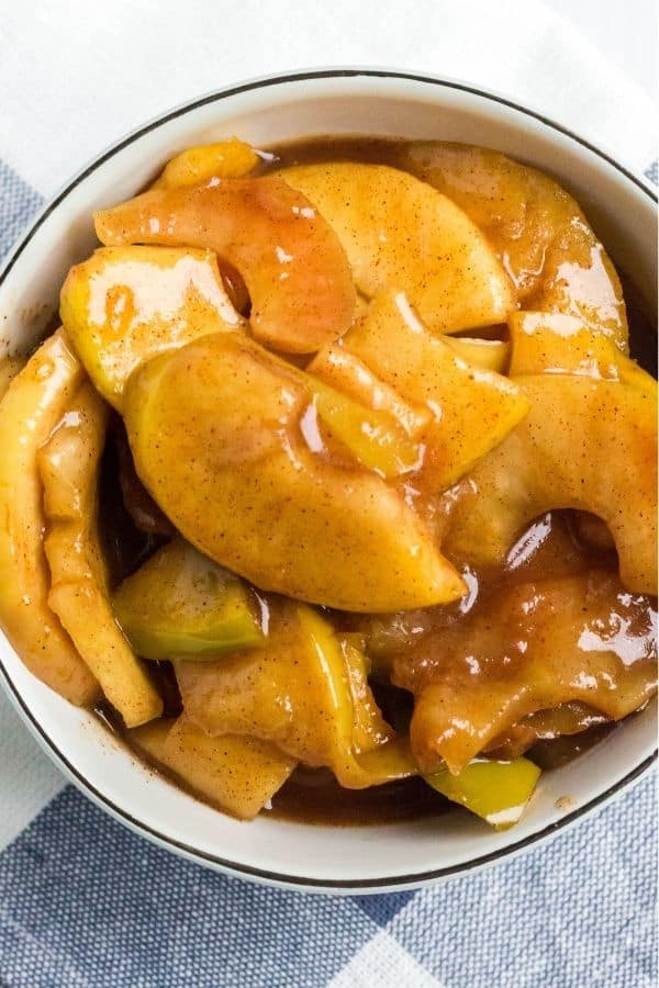 A serving of tender pressure cooker cinnamon apples in a cream-colored bowl.