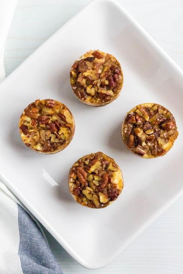 Aerial view of Instant Pot pecan pie cheesecake bites on a white serving plate