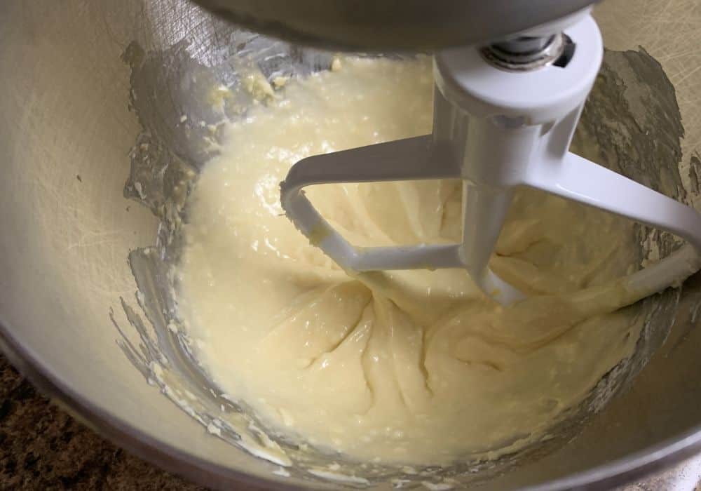 Butter, sugar, eggs, vanilla extract, and almond extract mixed together in a mixing bowl.