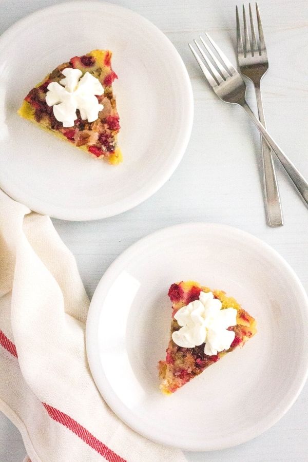 two white plates, each with a slice of Instant Pot Nantucket cranberry pie on it, with two forks off to the side