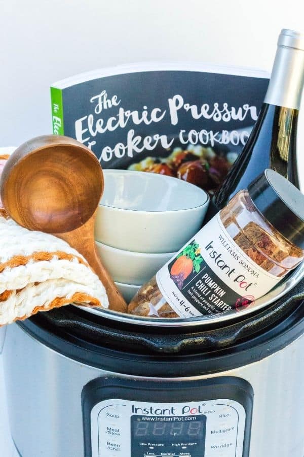 Soup-themed Instant Pot gift basket, filled with a soup starter mix, hand towel, ladle, soup bowls, and cookbook.