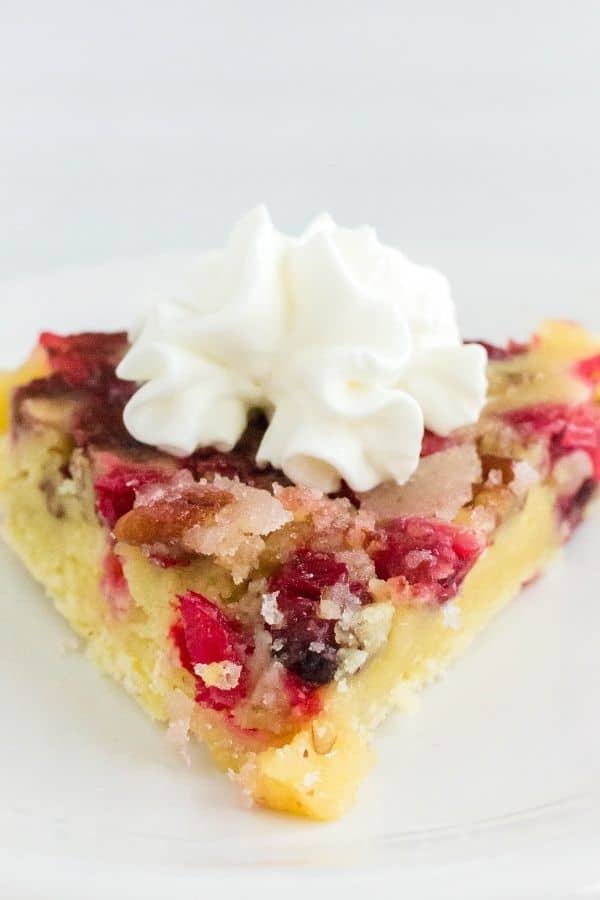 Close-up view of a slice of pressure cooker cranberry pie topped with whipped cream