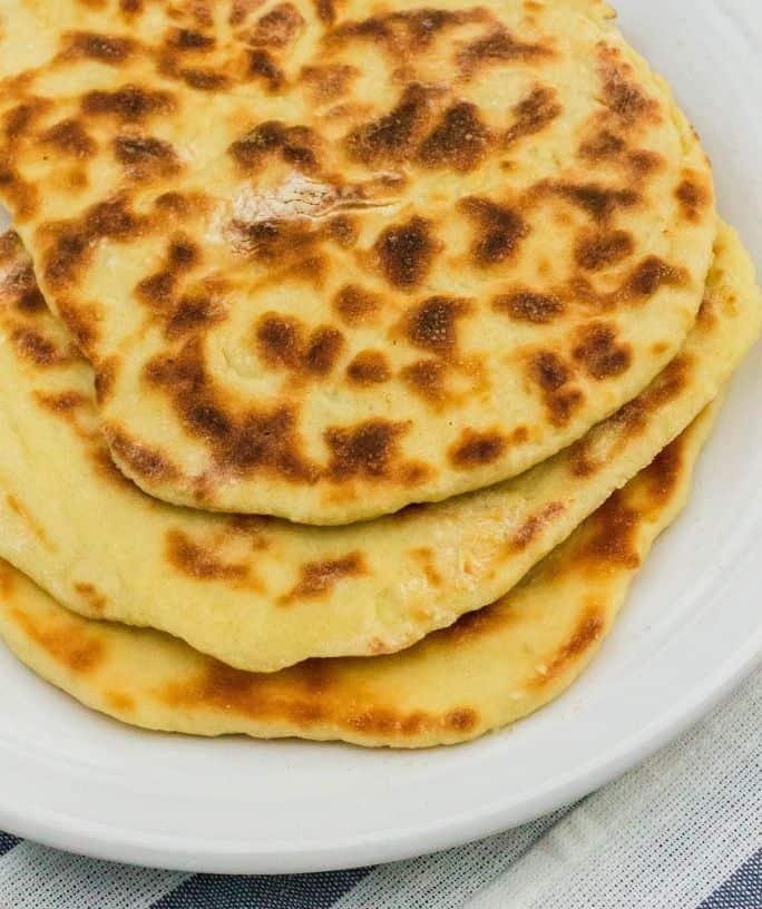 Indian restaurant styleInstant Pot naan bread on a white plate