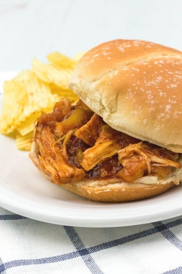 BBQ pulled chicken with pineapple that was cooked in the Instant Pot, served on a bun with some potato chips