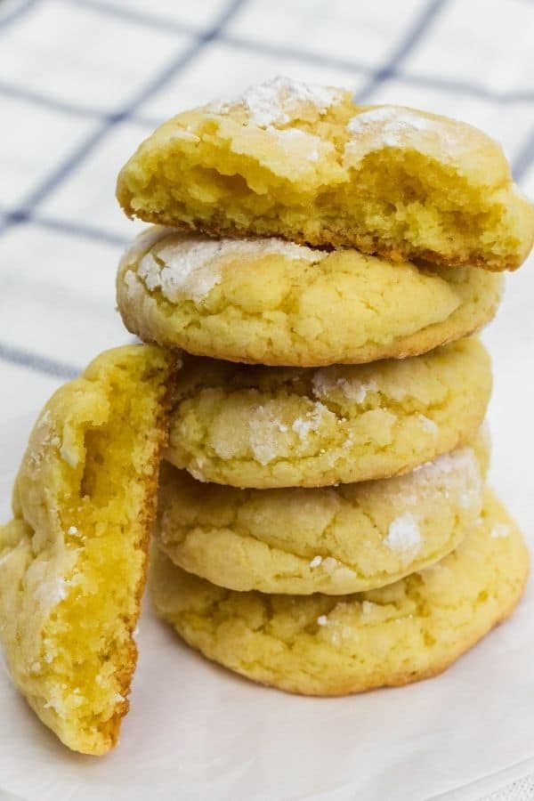 a stack of lemon pudding cookies, with the top one torn in half to show the soft interior