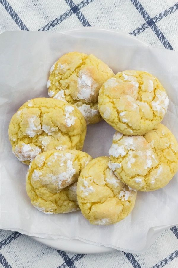 several lemon pudding cookies arranged in a circle on a parchment-lined plate