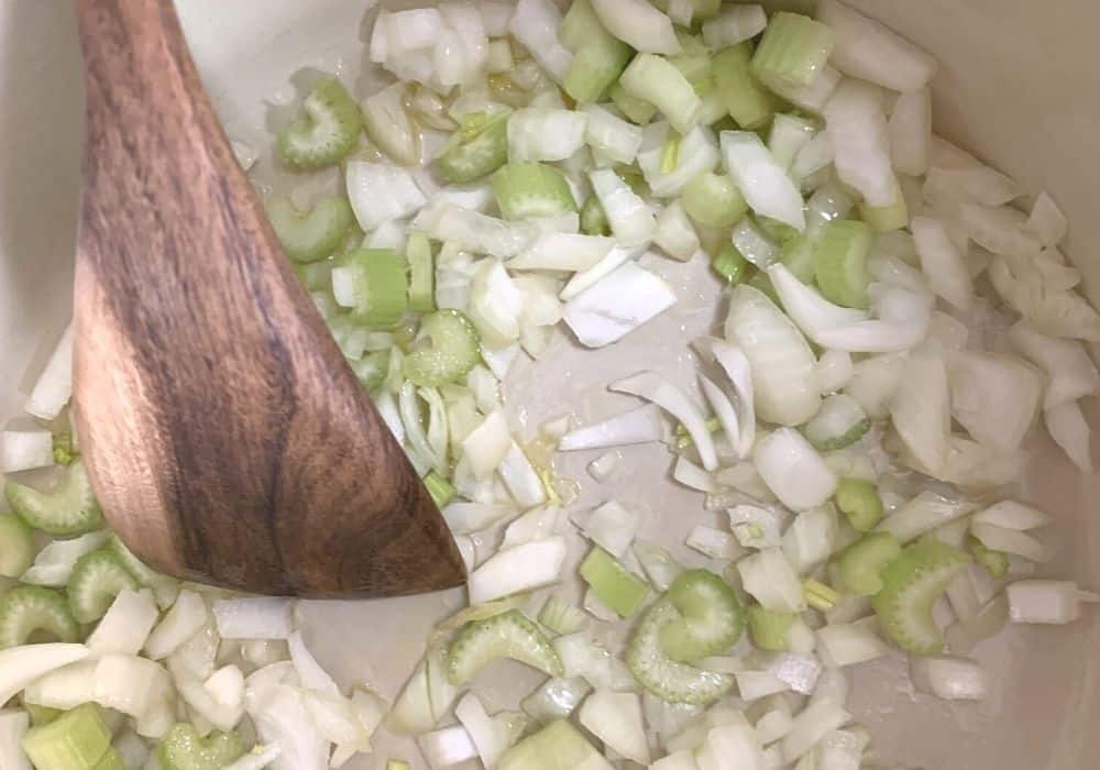 onions and celery sauteeing in olive oil in a dutch oven