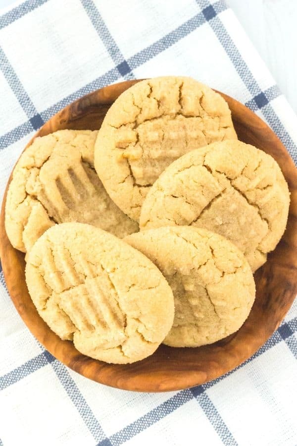 Five pancake mix peanut butter cookies arranged in a circle on a small wooden plate