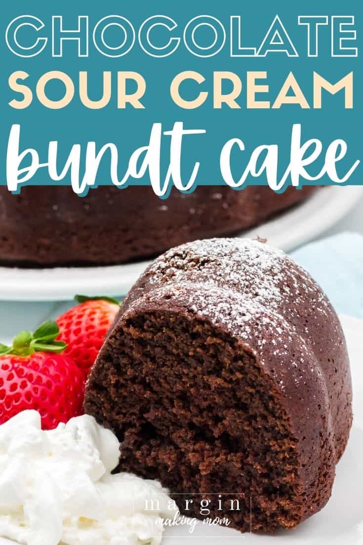 close-up view of a slice of chocolate sour cream bundt cake, served on a white plate with strawberries and whipped cream