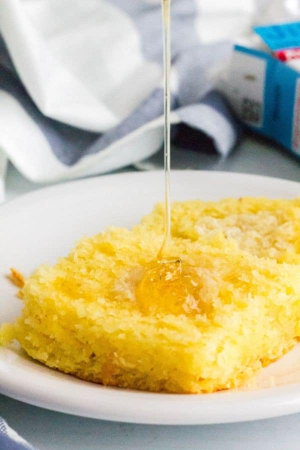 Piece of Jiffy cornbread being topped with honey