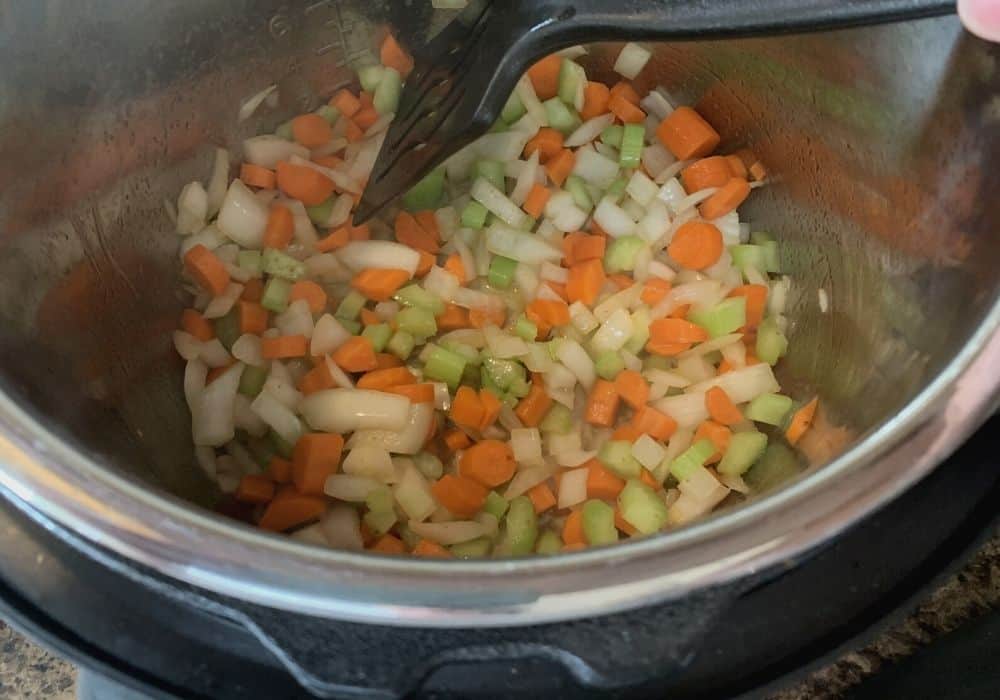 onions, celery, and carrots added to the insert pot to be sauteed.