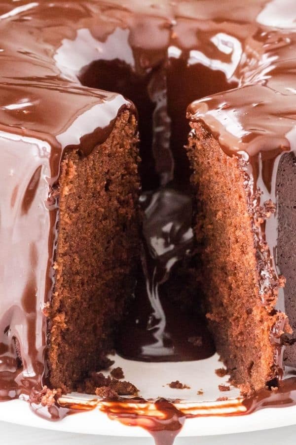 chocolate sour cream pound cake with a slice removed, showing the moist interior and the ganache flowing through.