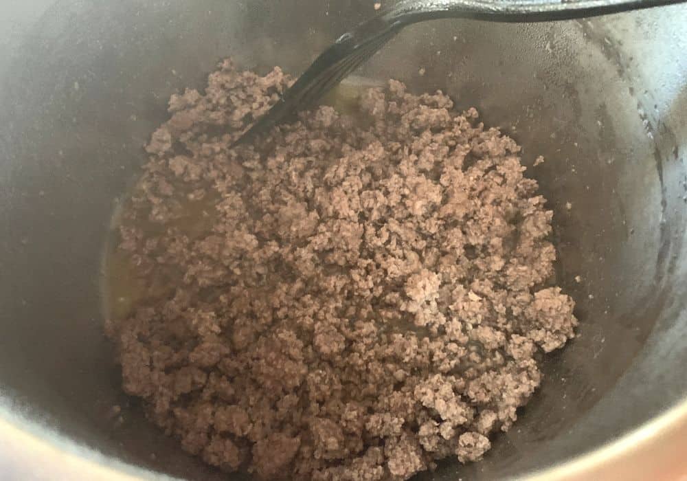 Ground beef being browned in the Instant Pot using the Saute setting.