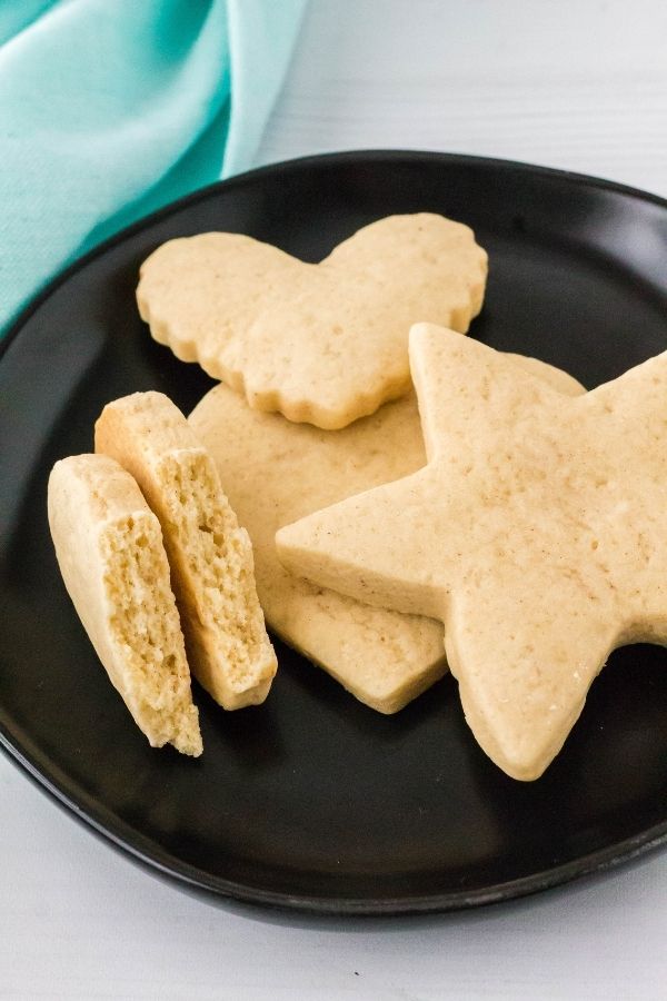 Italian sour cream cookies that have been cut into shapes, served on a black plate