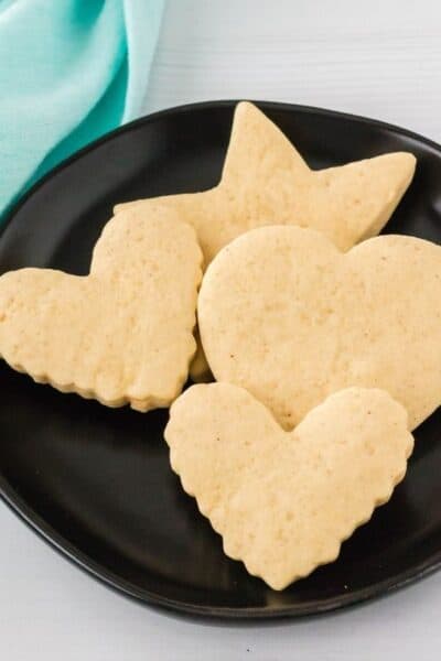 sour cream cutout cookies on a black plate