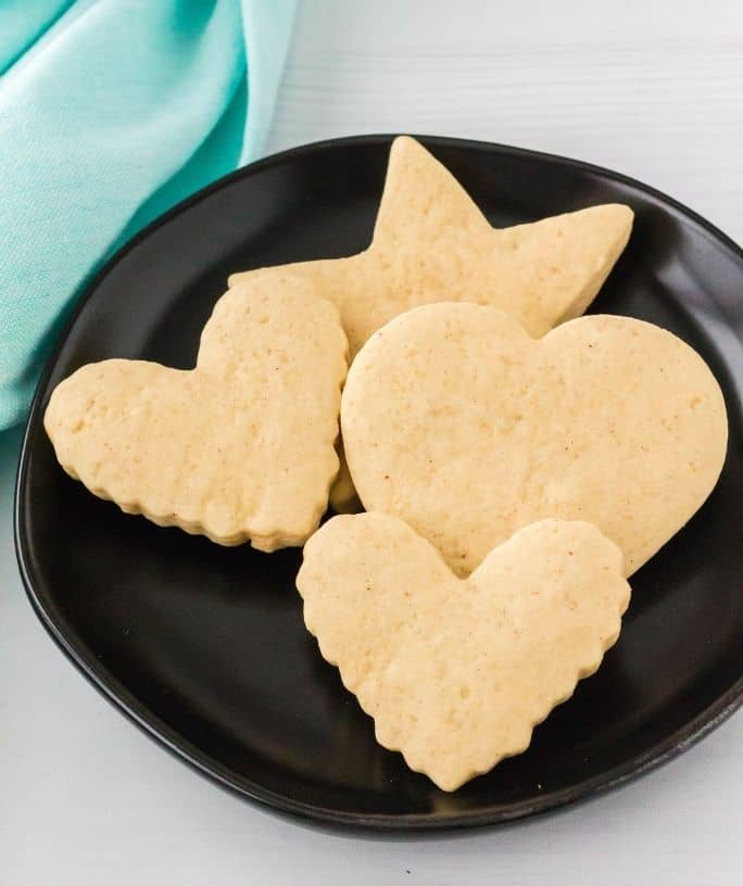 sour cream cutout cookies on a black plate