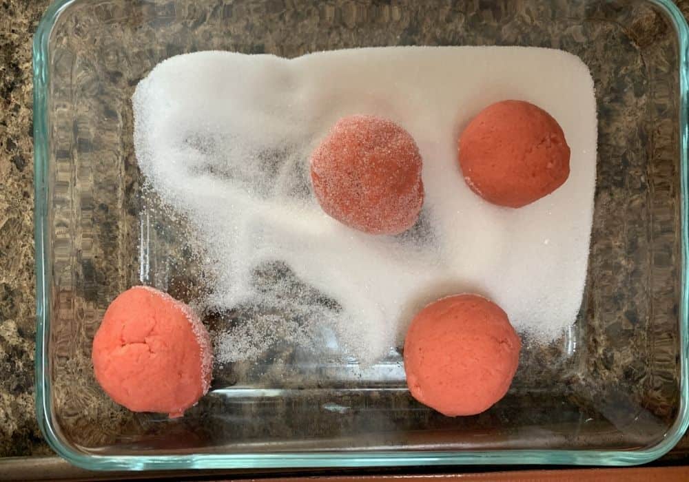 pink sugar cookie dough balls rolled in granulated sugar