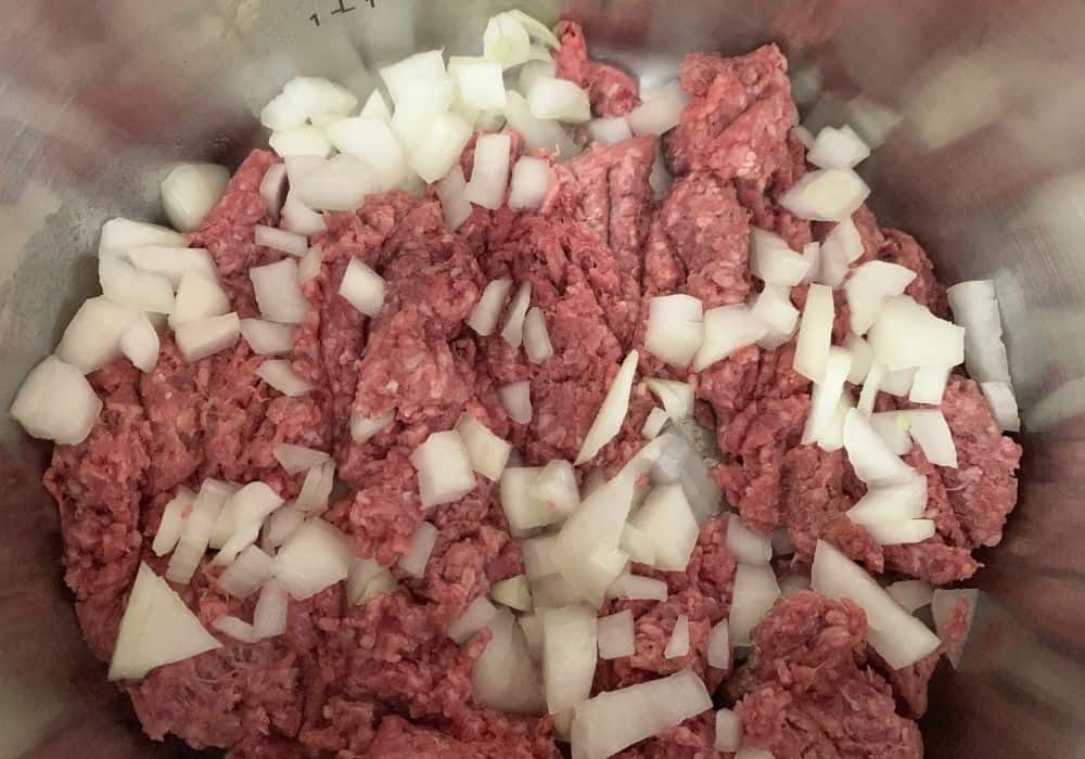 ground beef and onions in the insert pot of the Instant Pot for making sloppy joes