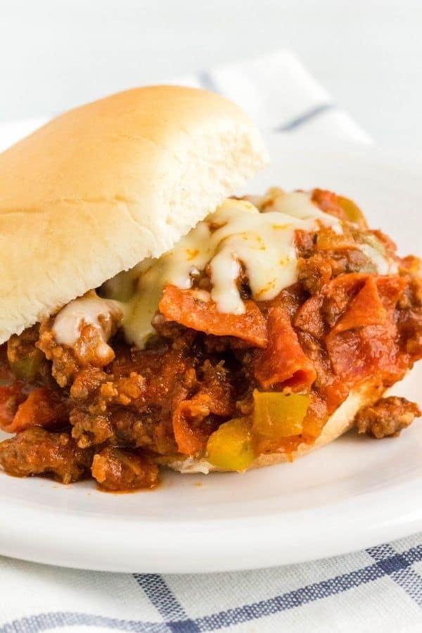 Instant Pot pizza sloppy joe filling on a bun, served on a white plate