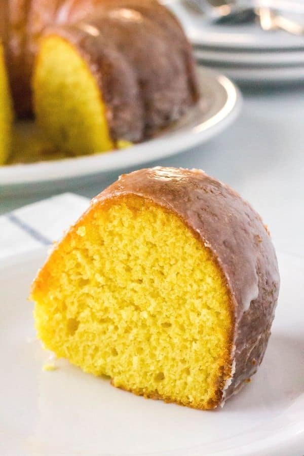 Upright slice of apricot cake on a white plate