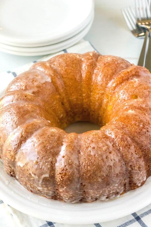 southern cake made with apricot nectar served on a white plate, with plates and forks in the background