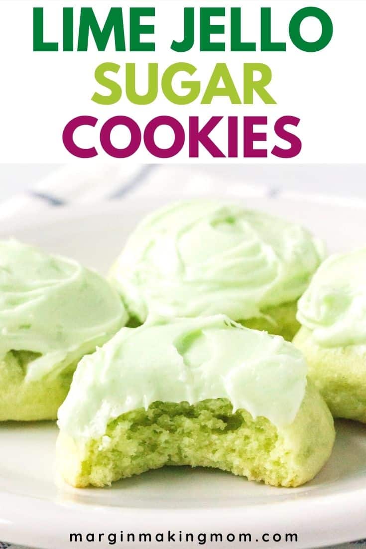 four frosted lime jello sugar cookies on a white plate, with a bite taken out of the front cookie to show the soft interior