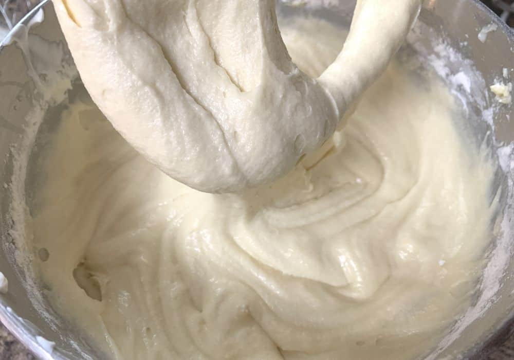 sour cream pound cake batter in the bowl of a stand mixer, ready to have diced peaches folded in.