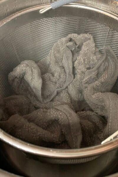 an image that shows how to steam dish cloths in the Instant Pot, with gray wash cloths in a steamer basket