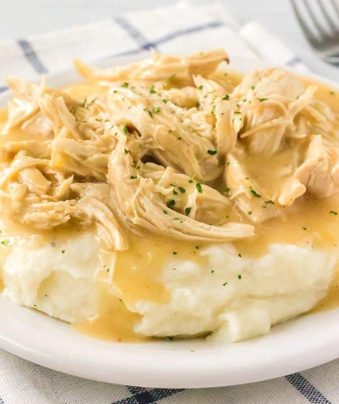 a bed of mashed potatoes covered with instant pot chicken and gravy
