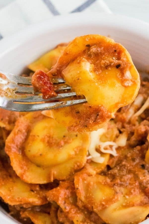 close-up view of Instant Pot ravioli lasagna, with a fork lifting out a piece of ravioli