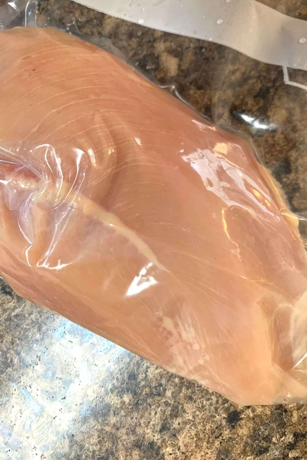 chicken breast in a ziploc bag after using the displacement method to remove air from the bag