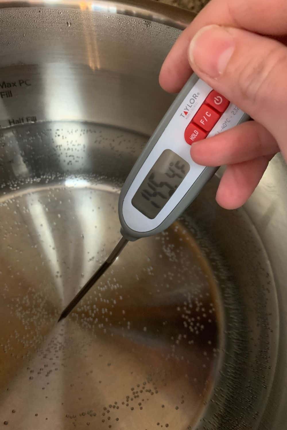a digital thermometer checking the temperature of the water bath for instant pot sous vide cooking