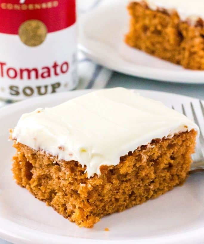 slice of tomato soup cake in front of a can of tomato soup