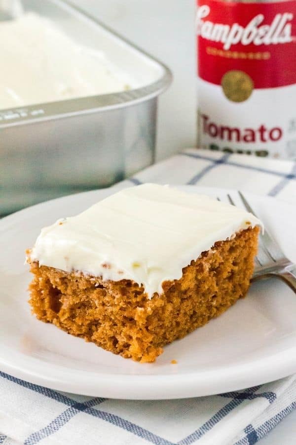 spice cake made with tomato soup, topped with cream cheese frosting, and served on a white plate