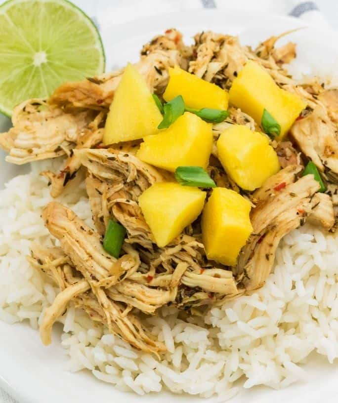 a plate of Instant Pot jerk chicken served over rice and topped with mango and green onions