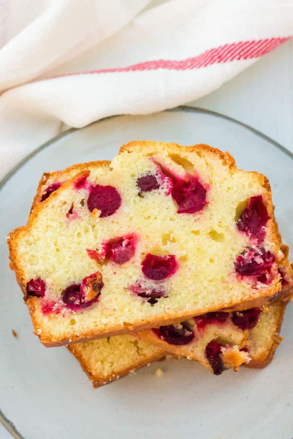 slices of cranberry cream cheese bread stacked on a plate