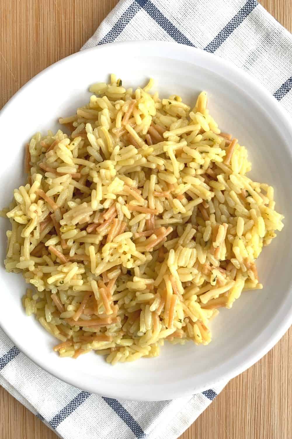 a helping of pressure cooked Knorr rice sides on a white plate atop a blue and white checkered napkin