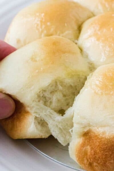 hand pulling apart Rhodes dinner rolls that rose from frozen in the Instant Pot